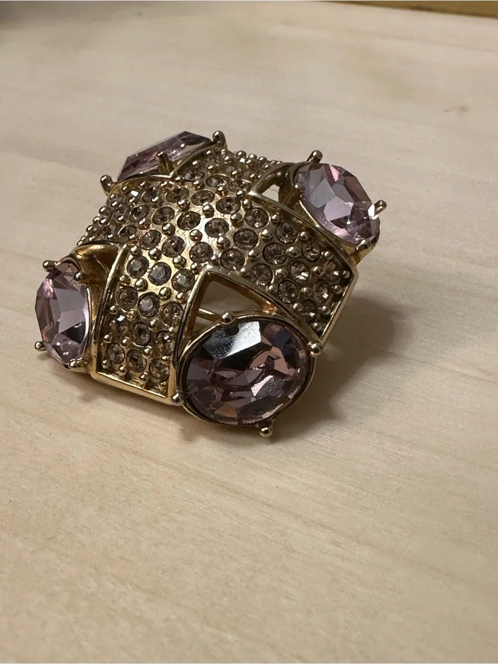 Monet gold-tone brooch with an abstract geometric design with purple stones